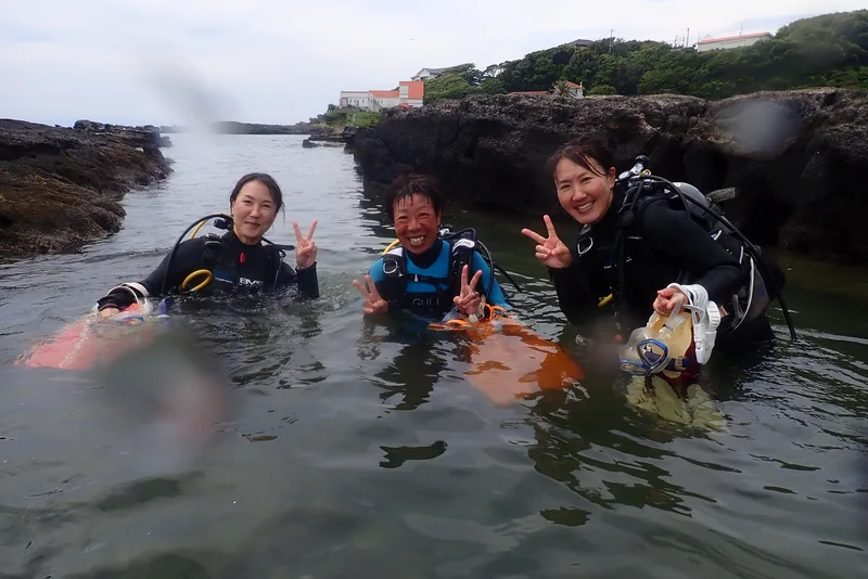 三浦の海で笑顔を見せるお客様3人