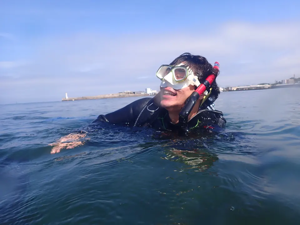 城ヶ島・梶の浜ビーチの水面で、笑顔を見せるダイバー