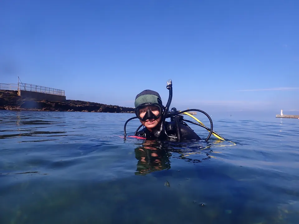 城ヶ島・梶の浜の穏やかな海と、白い灯台の見える堤防